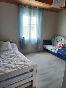 奥雷龙圣但尼Grande maison de vacances récente的一间卧室配有床和蓝色窗帘的窗户 更多6张照片