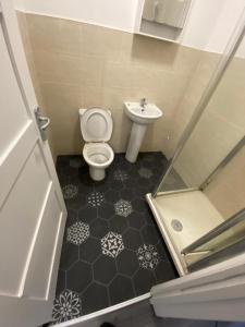 a small bathroom with a toilet and a sink at Sweet Dreams in Luton