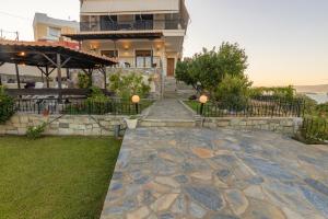 a house with a stone walkway in front of it at Villa Galani Agios Stefanos in Volos