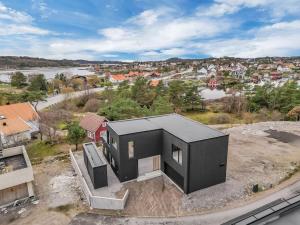 a black house sitting on top of a field at Feriested ved Strand & svaberg in Kristiansand