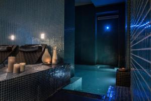 a bathroom with a tub and a shower with blue lights at Hotel C2 in Marseille