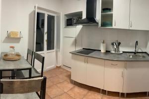 a kitchen with a sink and a table and a counter at A Casa do Sastre 2 in Ribadavia