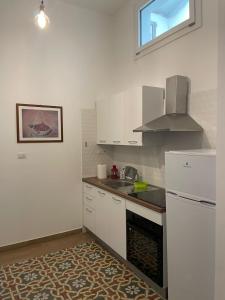 a kitchen with a white refrigerator and a sink at Il Canto del Gallo in Crotone