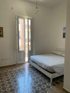 a bedroom with a bed and a door with a window at Il Canto del Gallo in Crotone