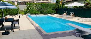 a swimming pool with a table and chairs and an umbrella at B&B Casa Silingardi in Bagnolo San Vito