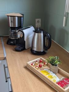 Una encimera de cocina con una cafetera y una tabla de cortar con manzanas. en Le Casselardit -T4 proche Hôpital - Clim - Balcon, en Toulouse