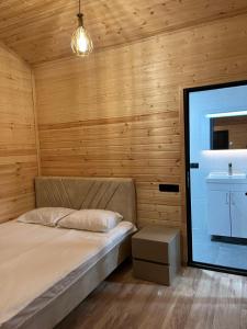 a bedroom with a bed and a sink and wooden walls at Cascade Resort Sevan in Sevan +53 photos
