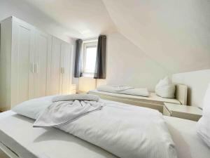 ein weißes Schlafzimmer mit zwei Betten und einem Fenster in der Unterkunft SAD403 - Geräumig eingerichtete Monteurwohnung in Schwandorf in Bayern
