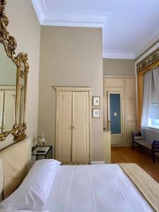 a bedroom with a white bed and a mirror at Monfort Club B&B in Campobasso