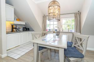 une cuisine avec une table et des chaises dans une cuisine dans l'établissement Roseneck App 6, à Tinnum