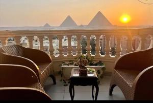 a balcony with chairs and a table and a railing at Pyramids Suite in Cairo