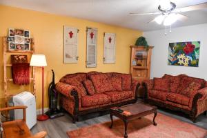 a living room with two couches and a ceiling fan at Cozy Cottage in Middle Grove