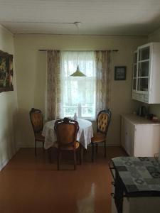a dining room with a table and chairs and a window at Hiirevända Holiday House in Võsu