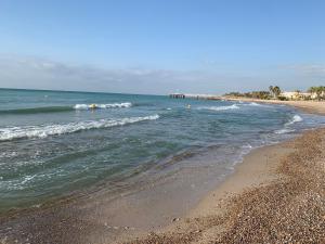 a beach with a rocky shoreline and the ocean at Casita Azul in Moncófar