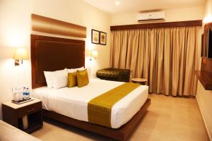 una camera d'albergo con un grande letto con cuscini gialli di Hotel Rameswaram Grand a Rāmeswaram