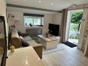 Maison en pierre, 3 chambres à 15 mn du centre de Menton et des plages في سان أجنيس: غرفة معيشة مع أريكة وتلفزيون