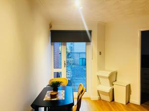 a dining room with a table and chairs and a window at Irene Suite By Koya Homes - 2-Bedroom Bungalow, Cardiff City Centre & Free Parking in Cardiff