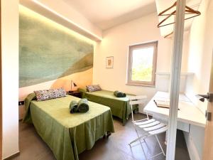 a room with two beds and a table and a window at Ostuni BLOOM piscina acqua salata vista mare in Ostuni