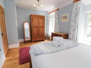 a bedroom with a bed with two towels on it at Cottage on the Green in Caernarfon