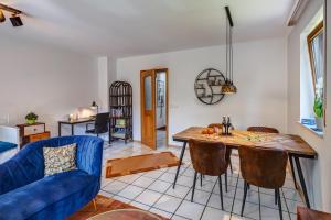 a living room with a blue couch and a table at Moderne Maisonette mit Garten in Unterschleißheim