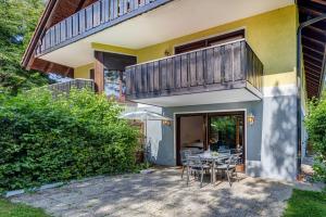 a patio with a table and chairs and a balcony at Moderne Maisonette mit Garten in Unterschleißheim