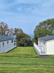 two white buildings on a grass field with trees at 18 Sea Valley Bideford Bay Park Dean in Bideford