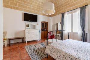 a bedroom with a bed and a tv on the wall at Holiday Home Dimora Effe in Castellaneta