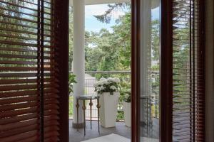 a room with a window with a vase of flowers at Apartamenty.in Jurata in Jurata