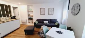 a living room with a couch and a table at Les Olivettes - Appartement calme au coeur d'Anduze in Anduze