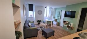 a living room with a couch and a table at Les Olivettes - Appartement calme au coeur d'Anduze in Anduze