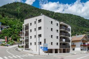 a white building on the side of a road with a mountain at SiJa in Mühlbach