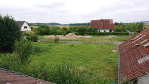 a view of a field from the roofs of houses at Ferienwohnung in Ländliche Gegend die zum Verweilen einlädt in Wachenroth