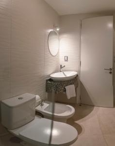 un bagno bianco con un water e un lavandino di Alegria Apart a San Rafael Altre 13 foto