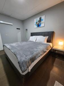 SiborongborongPorlak Hebron Family Homestay Silangit的一间卧室配有一张大床和床头柜