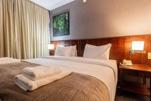 サンパウロにあるBHomy Blue Treeのタオルが敷かれたベッドのあるホテルの部屋