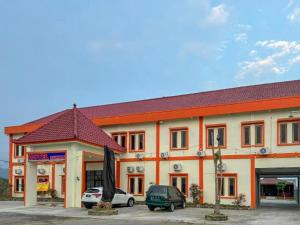 a large building with cars parked in a parking lot at Hotel Dewata YIA Kulonprogo in Sindutan +3 photos