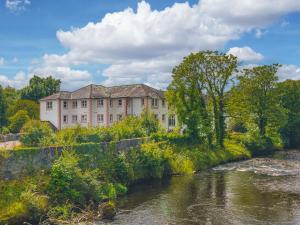 un grande edificio vicino a un fiume alberato di The Hytte, 19 Greta Grove House a Keswick