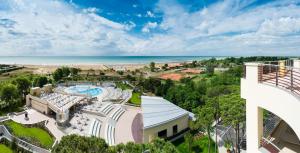 an aerial view of a resort with a pool and the ocean at Laguna Park Hotel 4Superior in Bibione