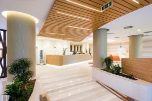an office lobby with wooden ceilings and plants at Laguna Park Hotel 4Superior in Bibione