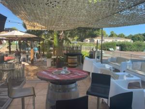 a patio with a table and chairs and an umbrella at Corse du sud Fiori di cala rossa T2 rez de jardin dans résidence piscine in Lecci