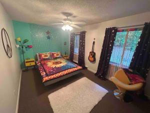 a bedroom with a bed and a guitar and a chair at Hot Tub Time Capsule with Waterbed & Jukebox in Middle Grove