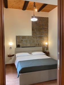 a bedroom with a bed and a brick wall at B&B Sunset Suite Belvedere in Sant'Agata de' Goti