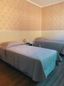 a room with two beds and a lamp on a table at O Paturi - Village Hotel Proximo Aparecida in Guaratinguetá
