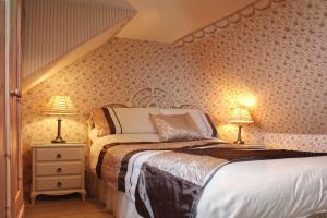 - une chambre avec un lit et deux lampes sur les tables dans l'établissement Airdaniar Cottage, à Applecross