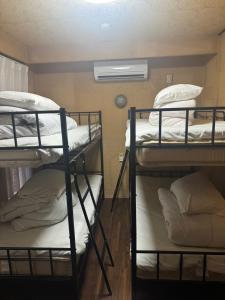 twee stapelbedden in een kamer met een raam bij Hikari Kitaayase - 光莉 北綾瀬 - 浅草や上野へアクセス良好 MAX11名の和風宿 無料Wi-Fi in Tokyo