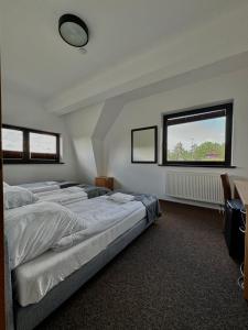 a bedroom with three beds and a window at WOSiR Szelment in Jeleniewo