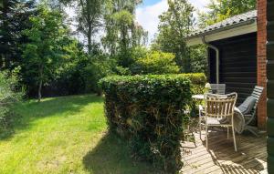 a chair sitting on a deck next to a house at Stunning Home In Ålbæk With Wifi in Ålbæk +19 photos