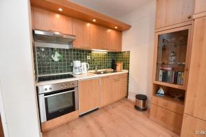 a kitchen with wooden cabinets and a stove top oven at Haus "Panorama" Appartement PAN056 in Duhnen