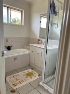a bathroom with a tub and a sink and a shower at Close to Hospital. WiFi, DogsOk in Point Vernon