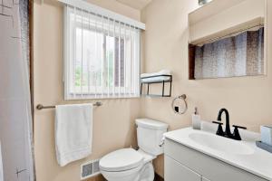 a bathroom with a toilet and a sink and a window at Stylish Comfy Shleby Retreat Patio Parking in Shelby +24 photos